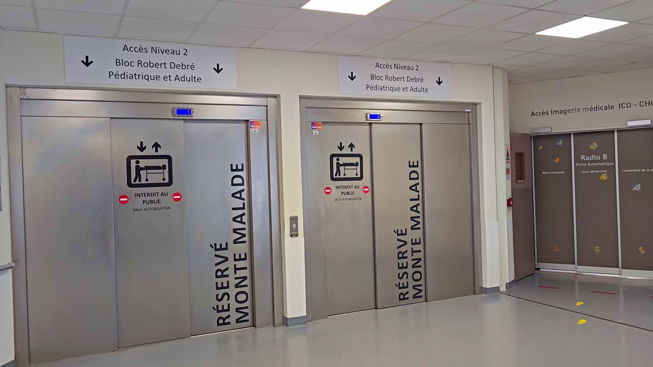 Static view of hospital elevators with medical access signs for pediatric and adult departments