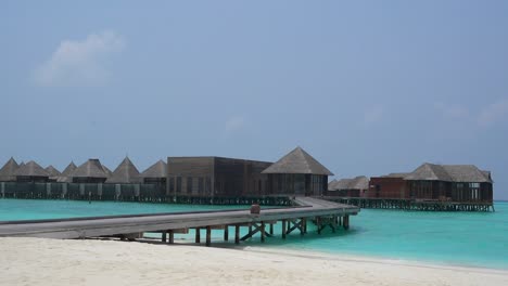 overwater buildings at maldives resort with blue water and clear sky