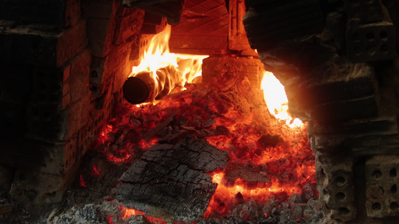 베트남의 thanh ha 도자기 마을에서 불타는 나무 오븐의 클로즈업, 전통 도자기 기술과 장인 정신을 보여줍니다.