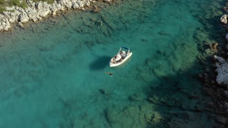 tourists on greece vacation swimming by boat in ionian sea island of paxos