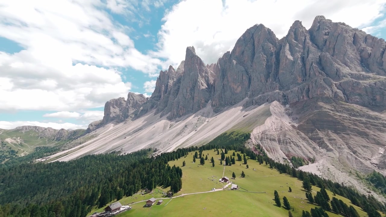 Vista aerea a 360 gradi della Valle di Ortisei e delle cime dolomitiche circostanti, sotto un cielo soleggiato vicino a Bolzano, Italia.