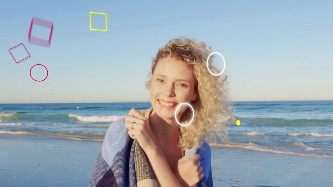 Donna che si gira verso la telecamera, la brezza le solleva i capelli, promuovendo i viaggi con uno scialle e forme sovrapposte