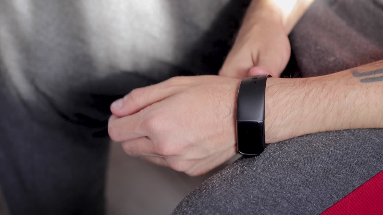 hombre sentado usando su reloj inteligente antes de ir a correr por la mañana