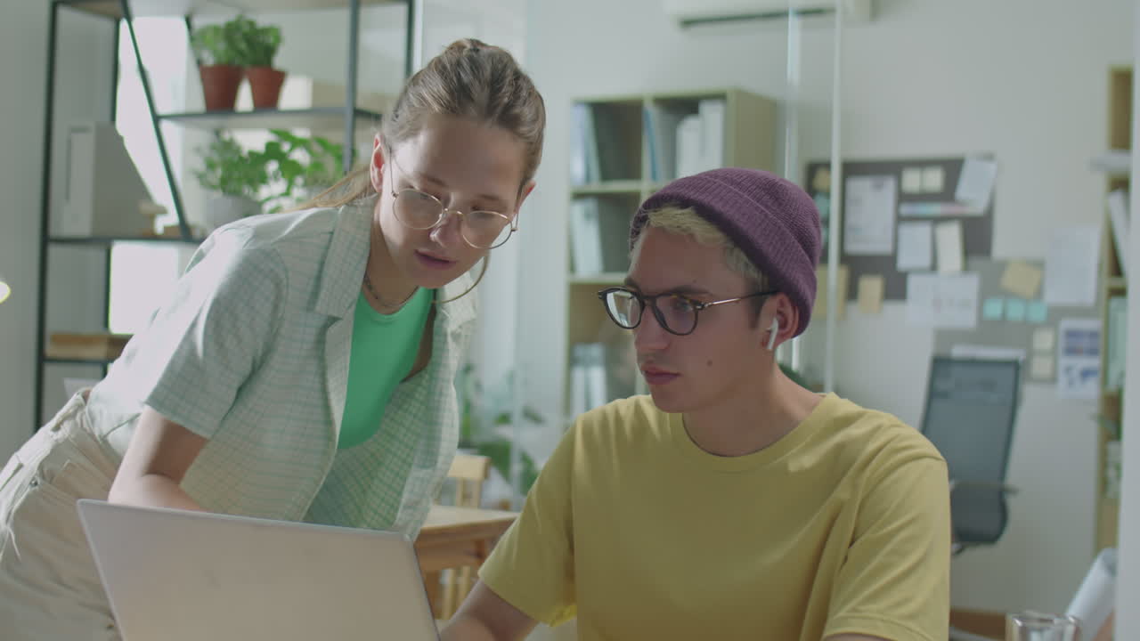 Gen Z Coworkers Discussing Business Project on Laptop in Office
