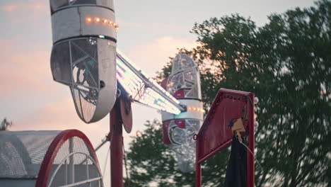 Roll-O-Plane-ride-at-carnival-during-sunset,-Slow-Motion