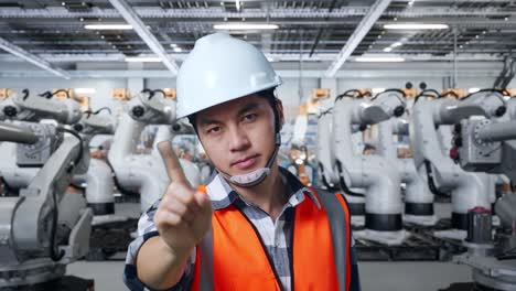 trabajador de fábrica advirtiendo de peligro cerca de robots