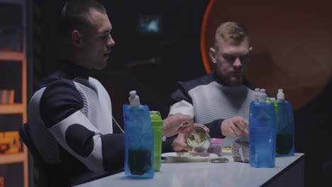 astronauts eating a meal in space