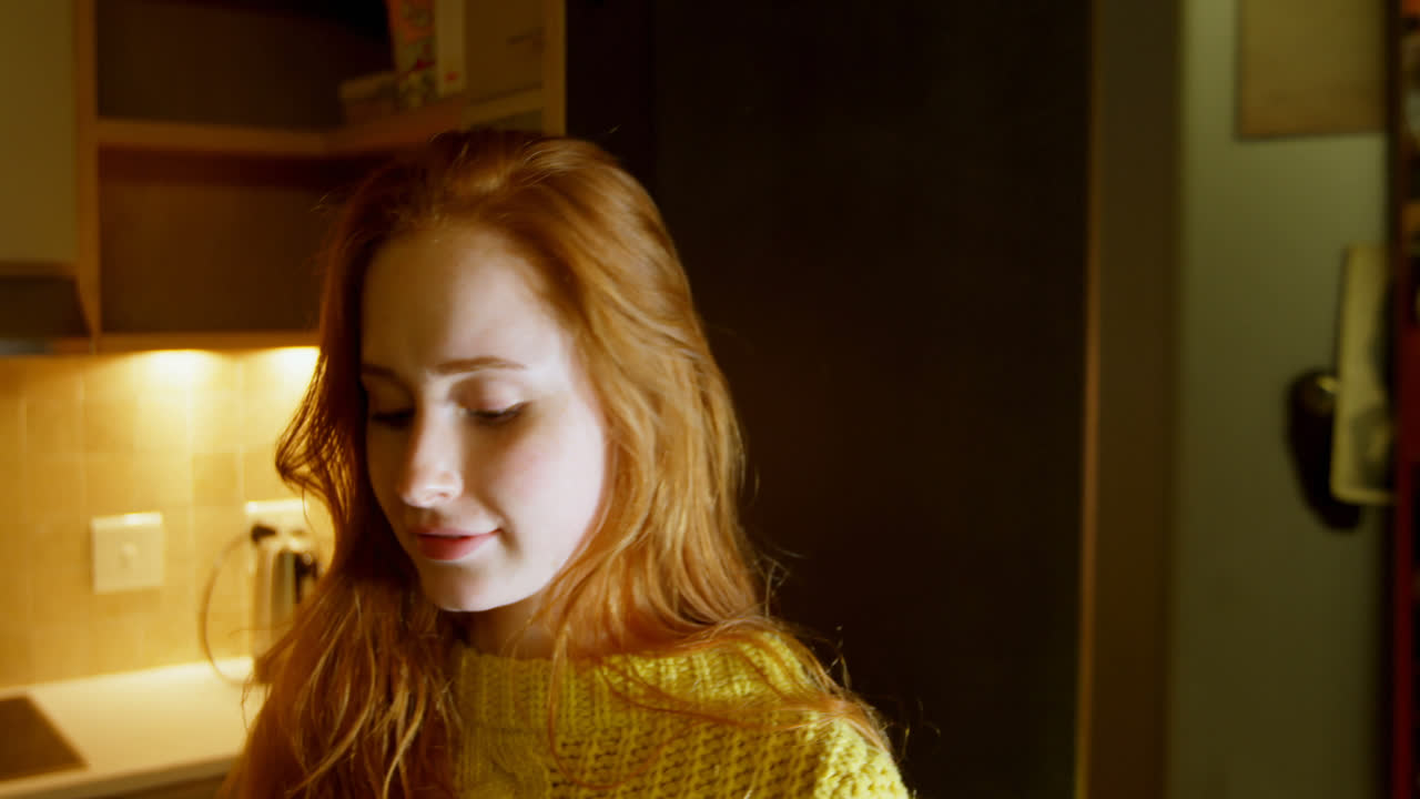 Woman having cupcake in kitchen 4k