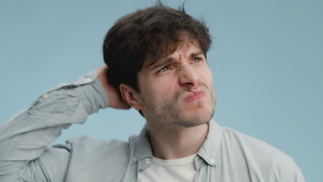 man in light blue shirt thinking