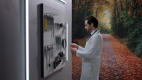 doctor selecting surgical instruments on a pegboard with an autumn forest background