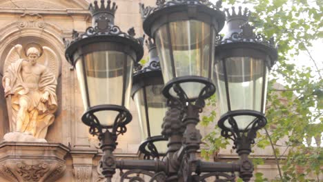 Facade-historic-building-with-stone-sculptures-on-background-street-lamp