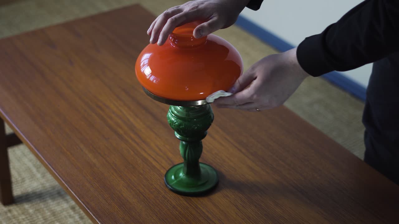 Handen reinigen een vintage tafellamp voor verkoop, ideaal voor antiek, wederverkoop, restauratie en content voor de woondecoratiemarkt