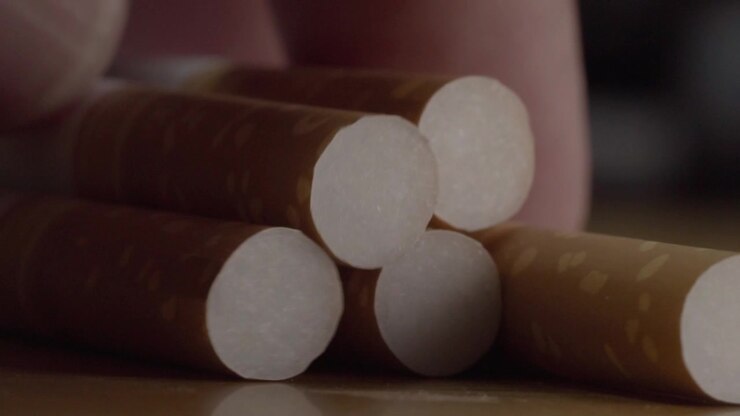Primo piano macro di diversi sigari marroni disposti insieme, che mostrano la loro forma cilindrica, la texture del tabacco, le estremità circolari e la dettagliata costruzione arrotolata.