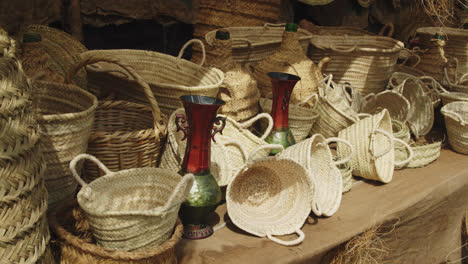 amazing shot of a group of handmade baskets made with yellow straw at a stand inside a medieval fair in andalusia, spain