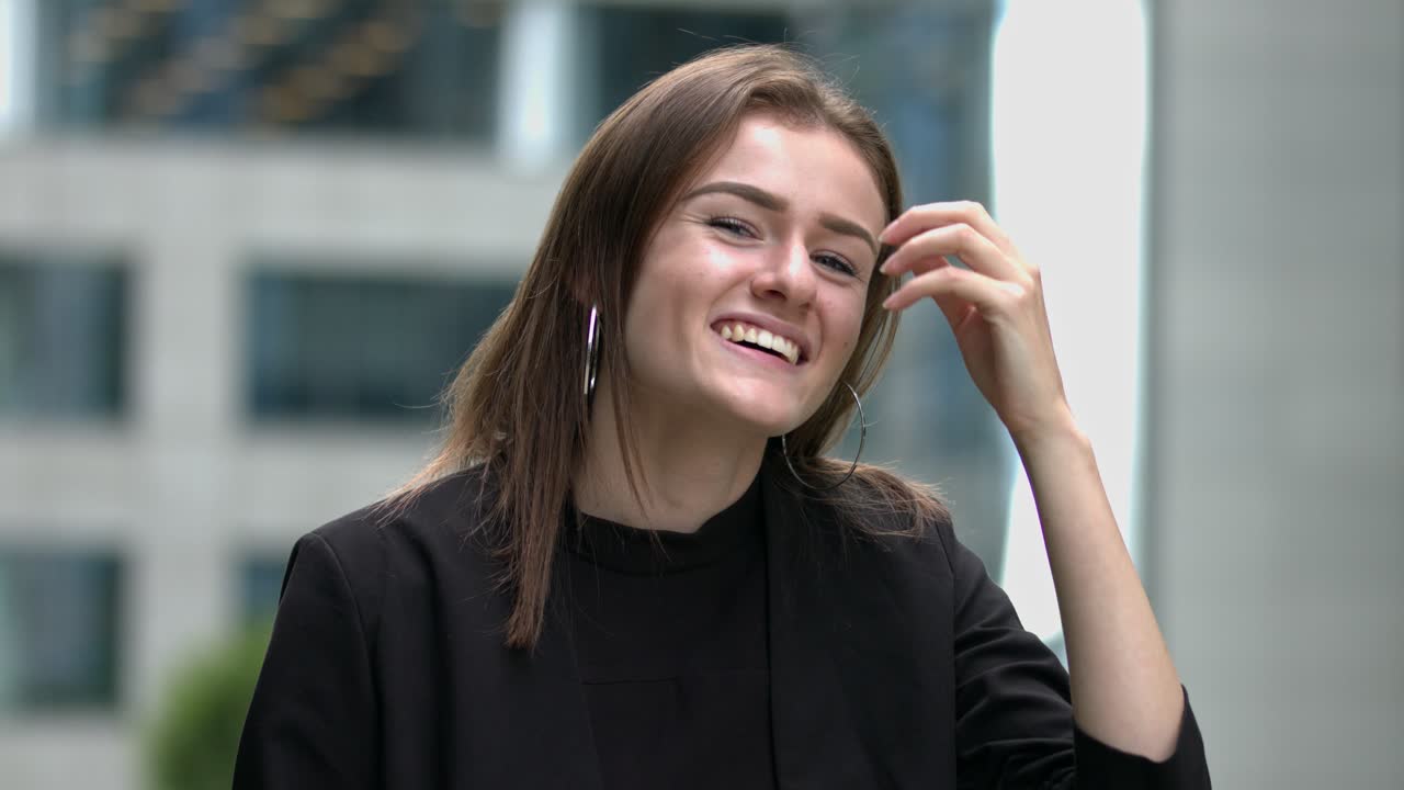 en un entorno urbano moderno, una joven sonríe y mira el entorno