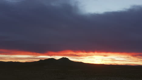 The-harsh-Mojave-Desert-climate-and-rugged-landscape-in-silhouette-as-the-sun-rises---aerial-view