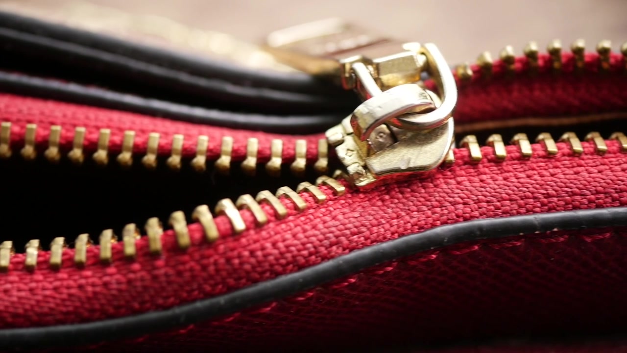 Primo piano della cerniera di una borsa in pelle rossa