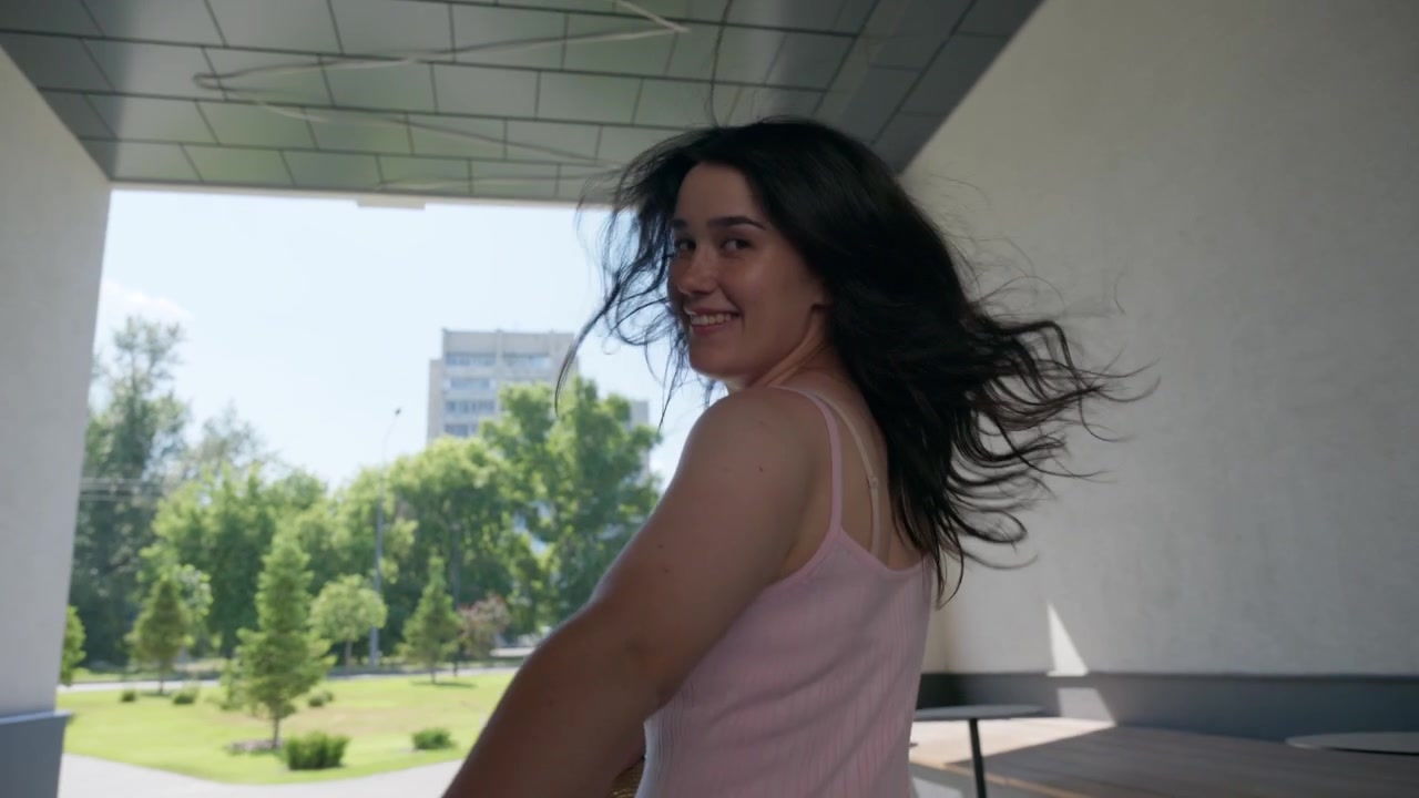 Giovane donna che tiene per mano e guida qualcuno lungo un percorso urbano