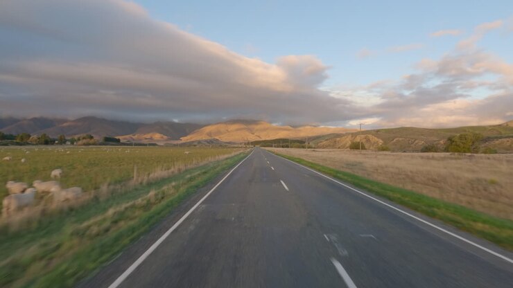 POV dall'auto che percorre la State Highway 85 lungo la Piana di Maniototo in Otago, Nuova Zelanda