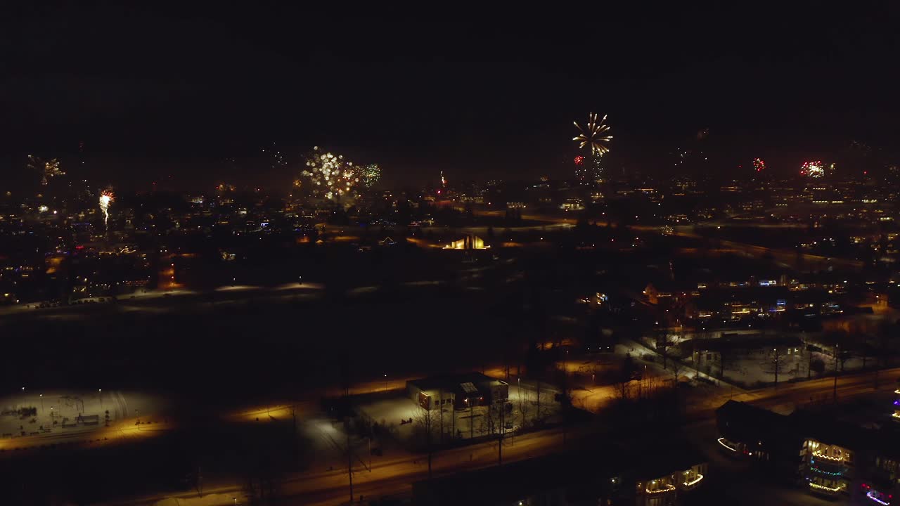 Fireworks Bursting Over Urban Landscape At Night. New Year's Eve Celebration In Iceland. aerial panning shot