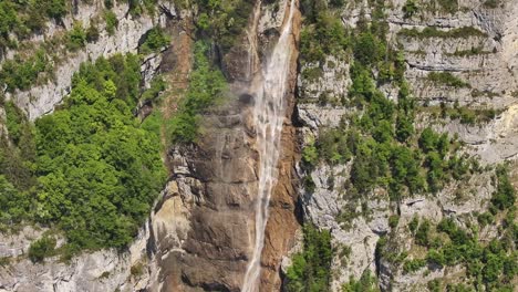 Drone rising to reveal Seerenbach Falls cascading down a cliffside near Walensee in Switzerland
