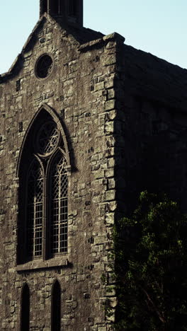 close up of a stone church with a large arched window