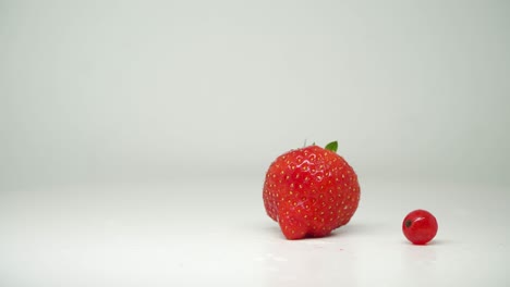 red strawberry and cherry fruits on turntable with pure white background - close up shot