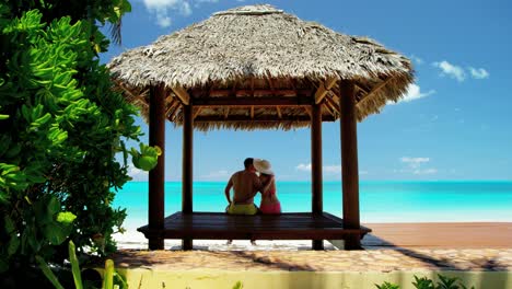 caucasian family sitting in a caribbean tiki hut