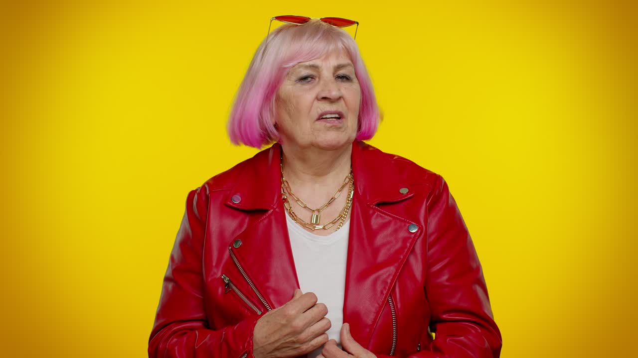 Nonna anziana scontenta e turbata che agita la mano e scuote la testa per respingere un'idea, non gradendo la proposta.