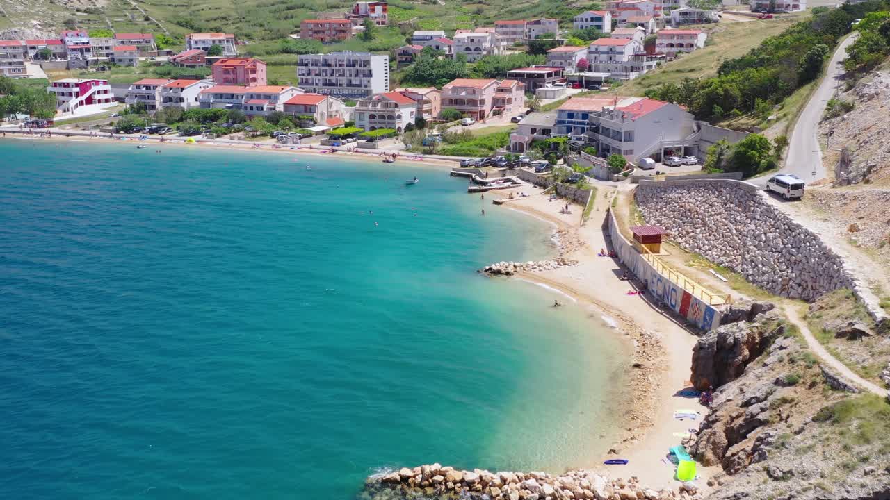 Aerial flying alongside Pag island coastline towards Pag town in Croatia