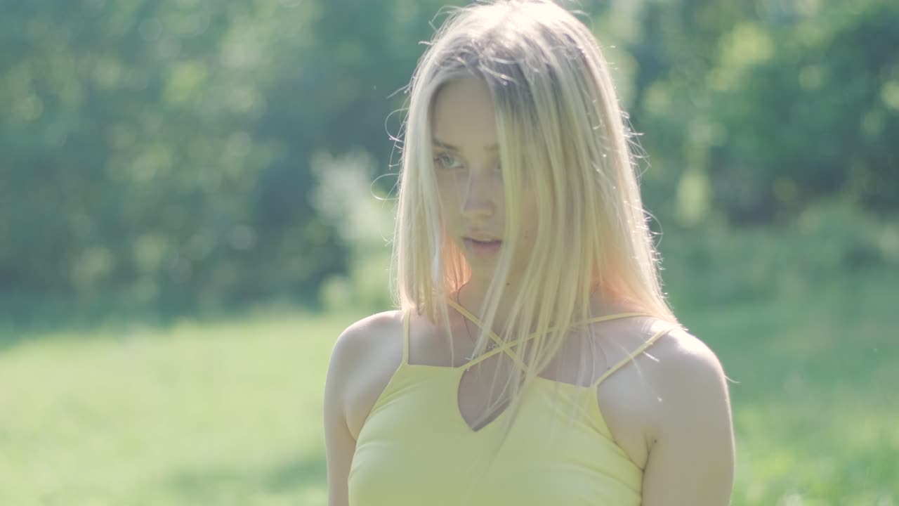 노란색 드레스를 입은 여자가 여름 공원에서 우아하게 춤을 춘다