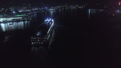 drone shot of a launch moving in a river at night