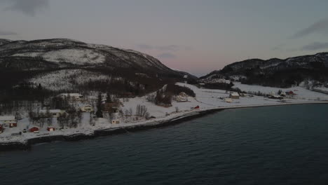 Snowy-Arctic-Village-With-Oceanfront-Houses-During-Polar-Night-In-Norway