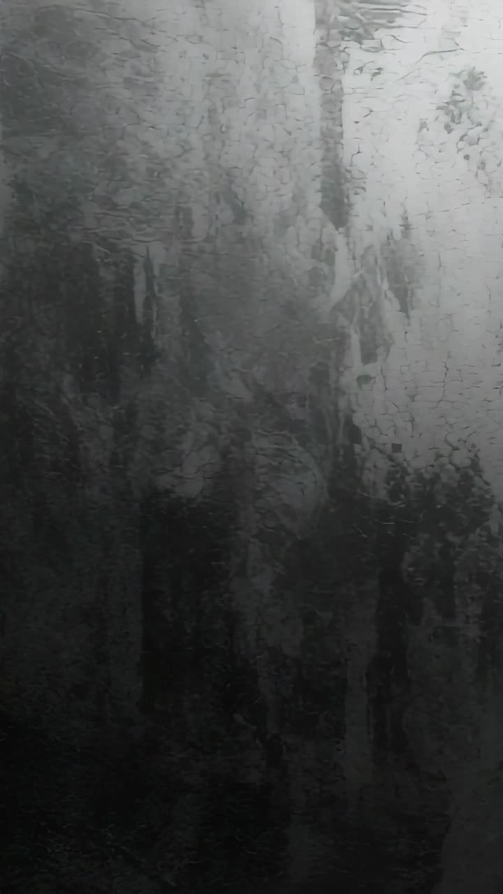 Video verticale: luce tremolante che rivela metallo graffiato, causando striature umide che gocciolano verso il basso