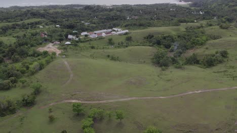 tilt up shot of green scenery at sumba island indonesia during cloudy day, aerial