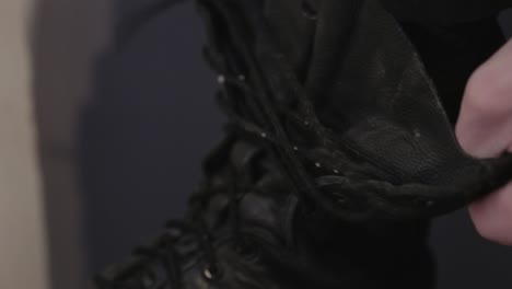 unlacing and taking off the black boots - close up shot