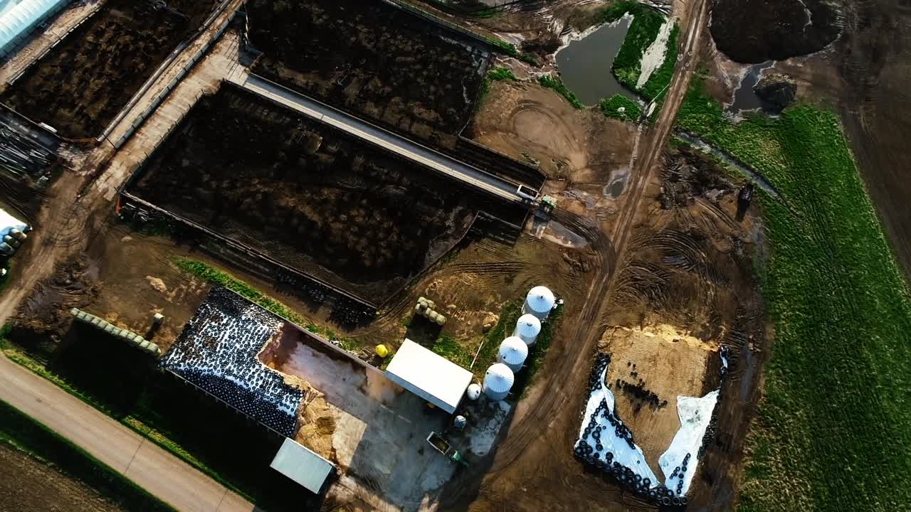 Drone top down shot of payloader loading cattle wagon as farmers do their daily morning chores feeding cattle.