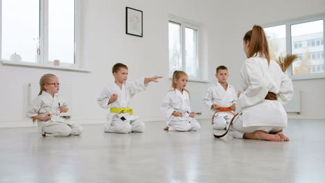 kids kneeling on the floor in martial arts class