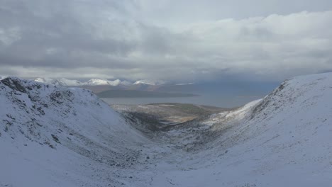 a snow covered valley leading to the ocean