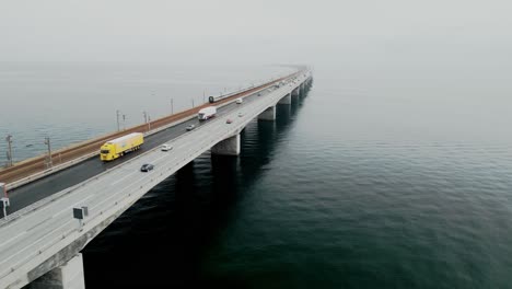 eine lange hängebrücke über die ostsee mit autos, lastwagen und einem zug