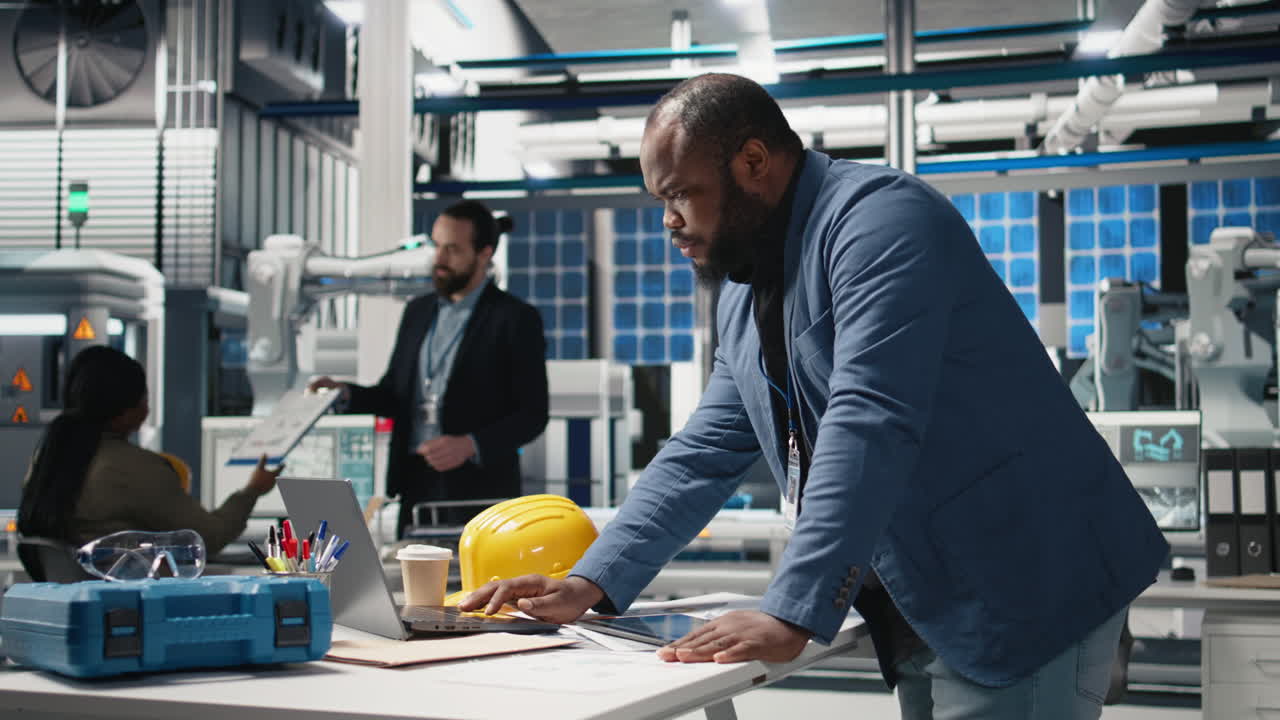 Engineers working in a modern manufacturing plant with robotic arms