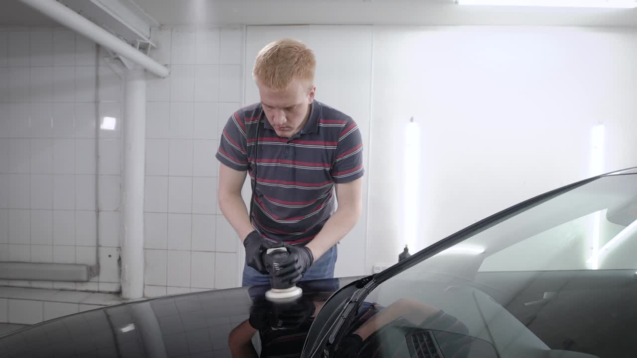 Man sedulously polishing bumper of car
