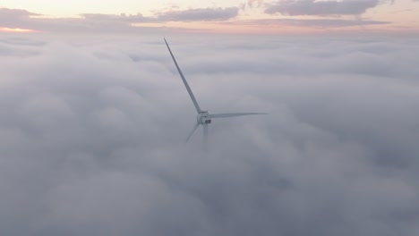 drone shot of a windturbine in foggy conditions