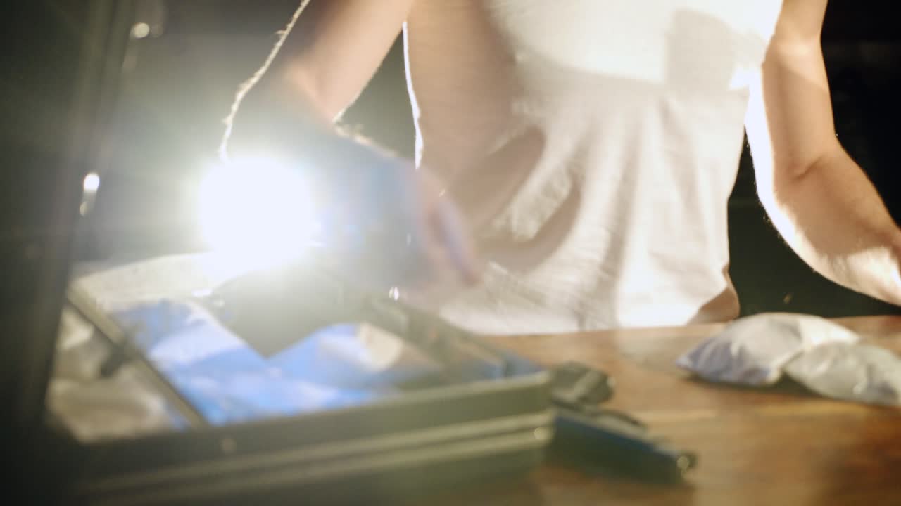 Gun, drugs and money. Drug dealer stacks the heroin filled bags. Criminal Business