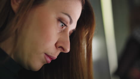 a woman deeply focused and working intently. captured with a handheld camera, this close-up shot highlights concentration and dedication. ideal for illustrating work, focus, and productivity