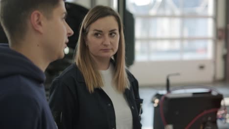 female manager discussing vehicle repair with mechanic in auto repair shop