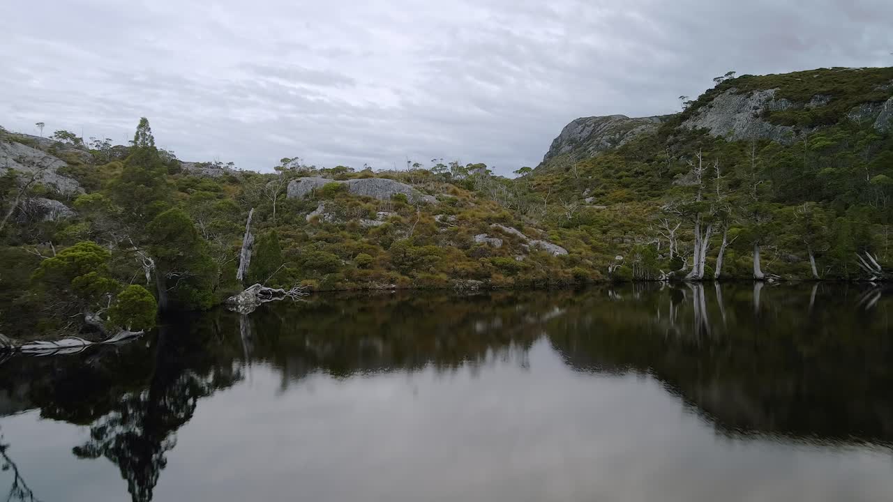 Low angle view of a pond with hills at background