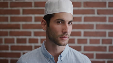 portrait attractive young muslim man turns looking pensive turns head confident independent businessman wearing kufi hat slow motion