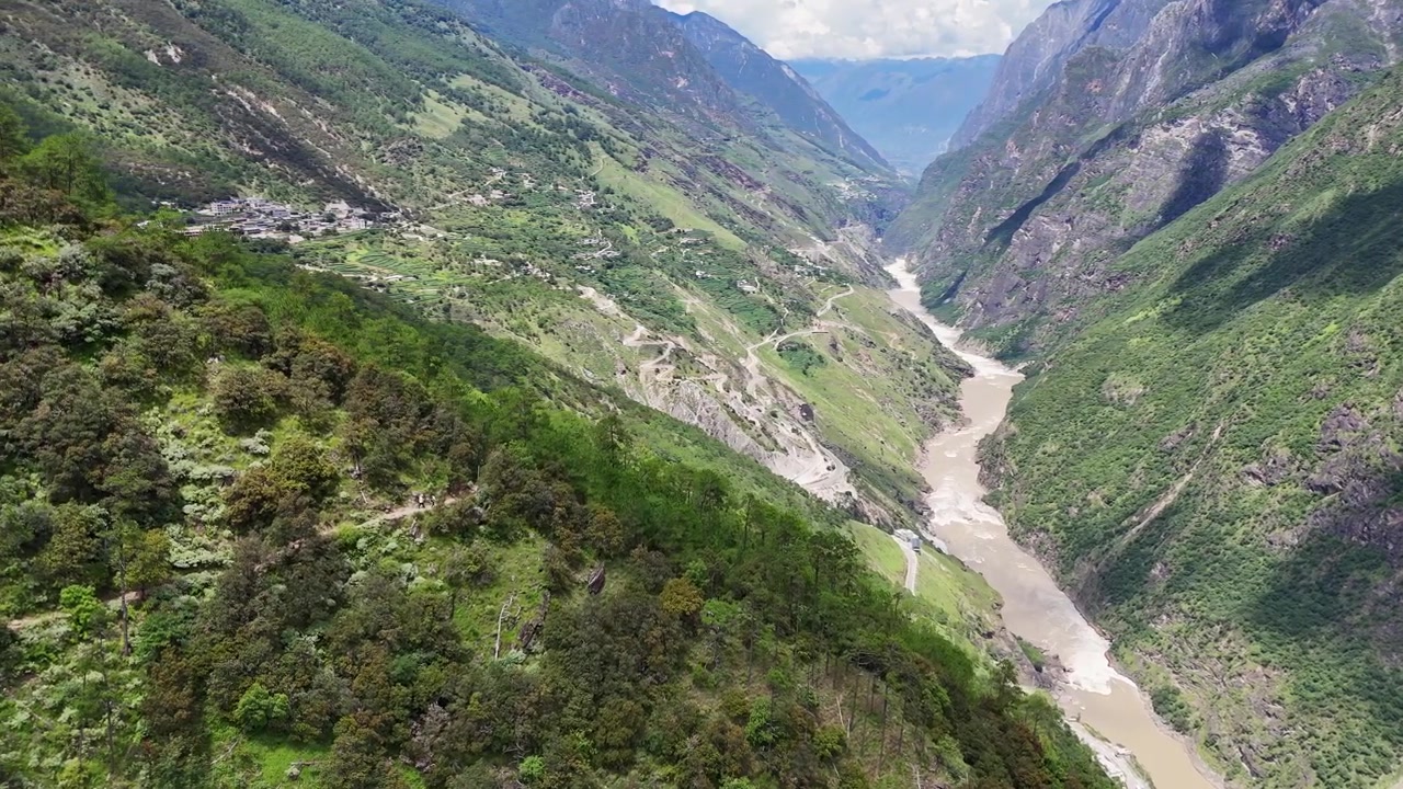 Passaggio aereo sopra un fiume serpeggiante e un crinale verde nella Gola del Salto della Tigre, panoramica a destra