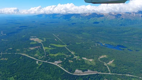 small airplane flight over the matanuska river near the town of palmer alaska with the talkeetna mountain range in the distance